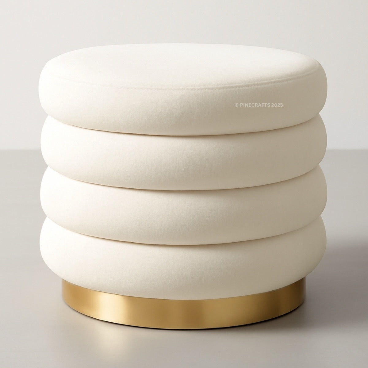 White ottoman with gold base on a light gray background
